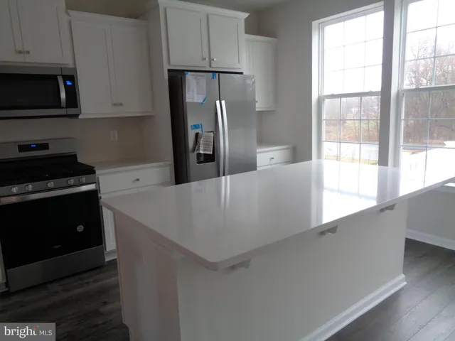 a kitchen with stainless steel appliances a refrigerator a stove a microwave and cabinets