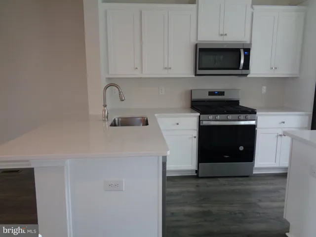 a kitchen with stainless steel appliances granite countertop a stove a microwave and cabinets
