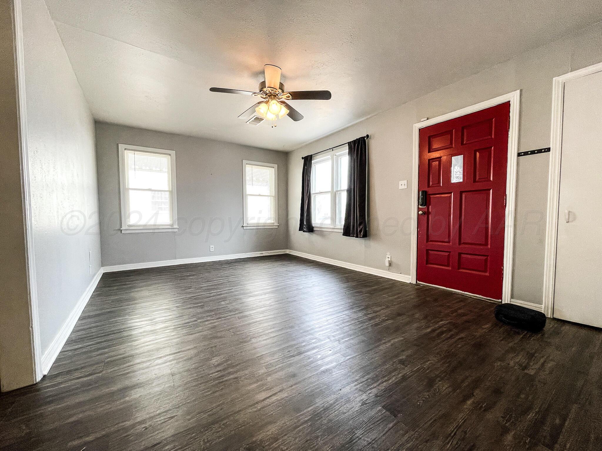 4110 South Lipscomb Street Amarillo, TX 79110 - Photo 4 of 16 wooden floor in an empty room with a window