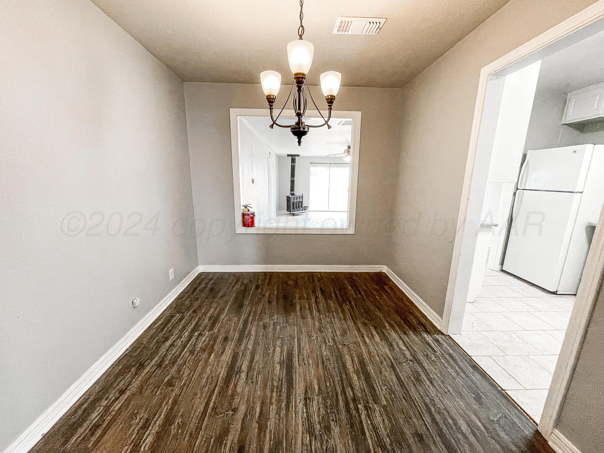 4110 South Lipscomb Street Amarillo, TX 79110 - Photo 5 of 16 a view of wooden floor in an empty room with a window