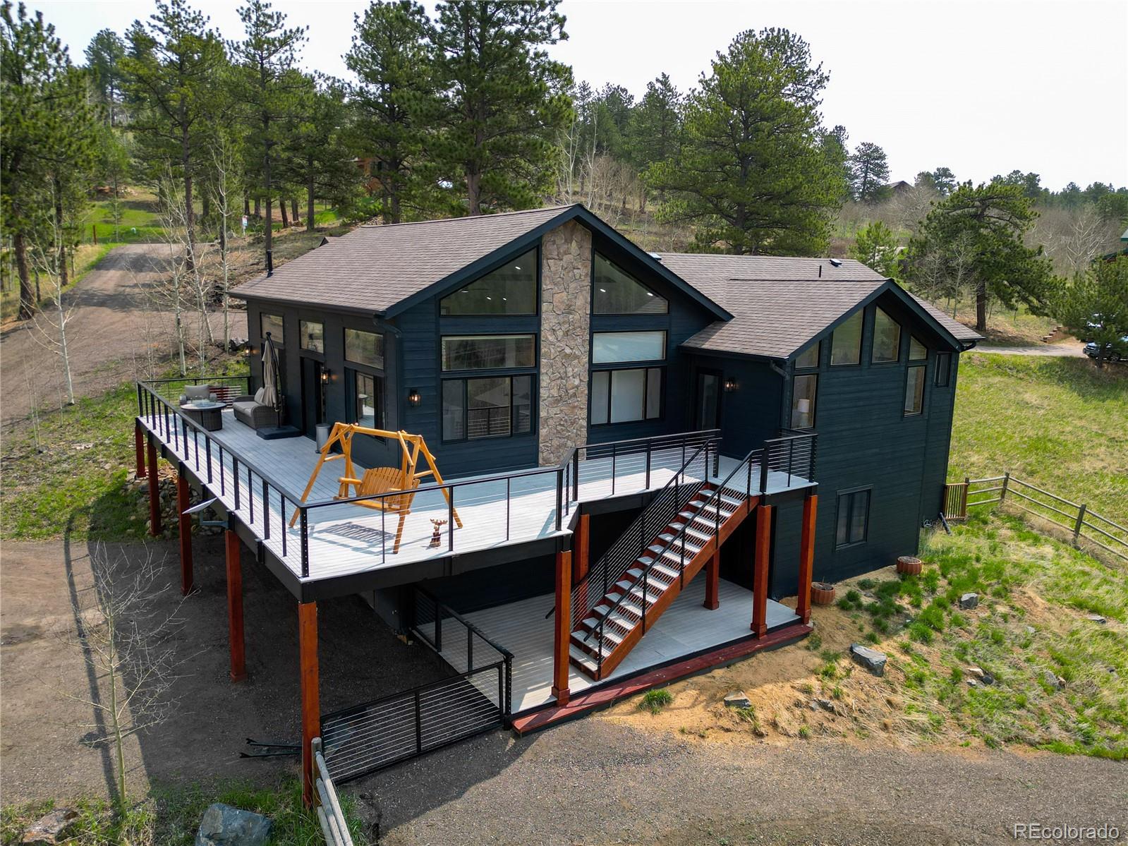 a view of a house with wooden deck and furniture