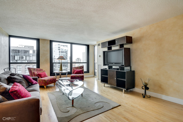 1030 North State Street, Unit 13D Chicago, IL 60610 - Photo 2 of 12 a living room with furniture and a flat screen tv