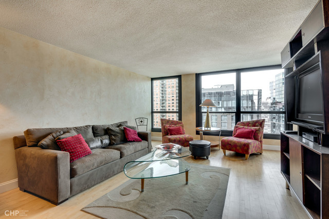 1030 North State Street, Unit 13D Chicago, IL 60610 - Photo 3 of 12 a living room with furniture and a flat screen tv