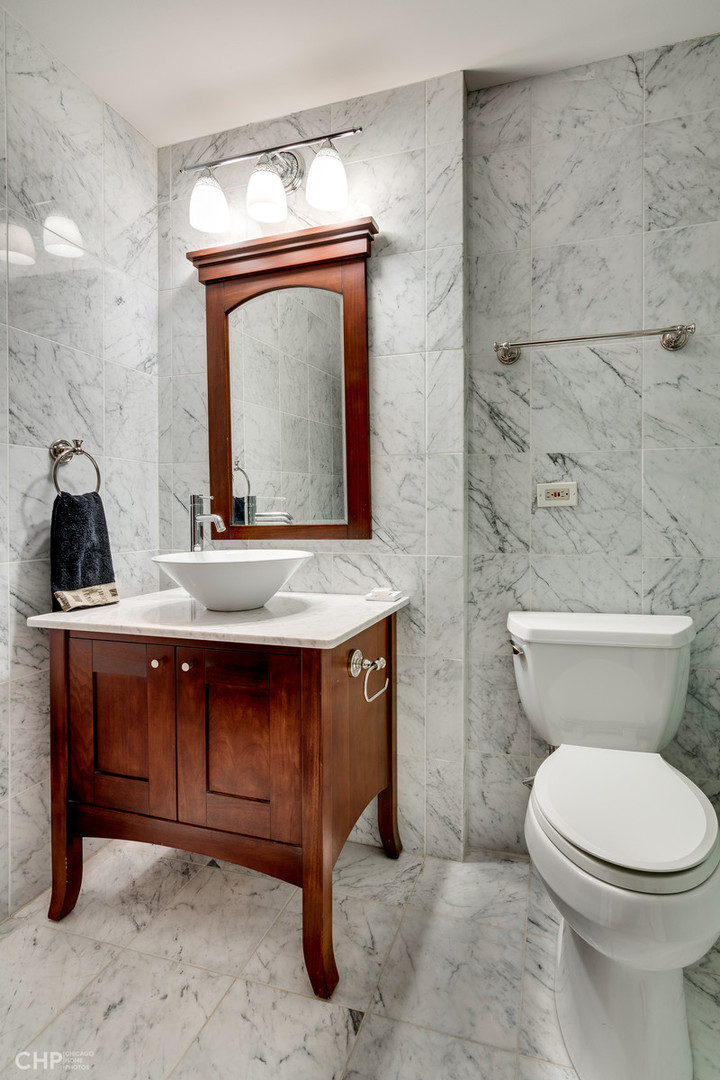 1030 North State Street, Unit 13D Chicago, IL 60610 - Photo 6 of 12 a bathroom with a toilet a sink and mirror