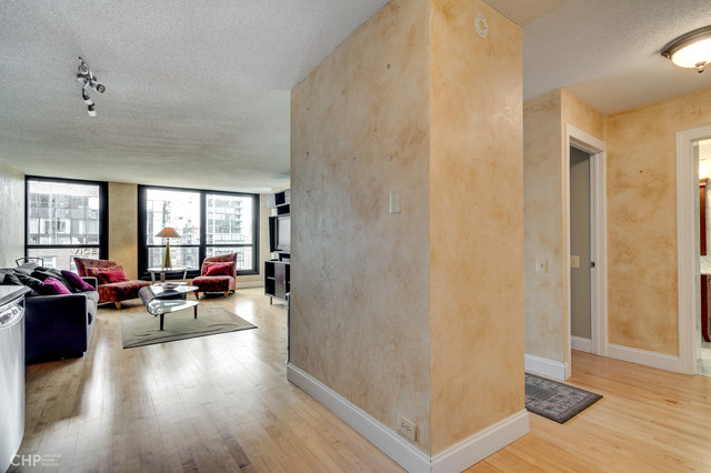 1030 North State Street, Unit 13D Chicago, IL 60610 - Photo 9 of 12 a living room with furniture and a wooden floor