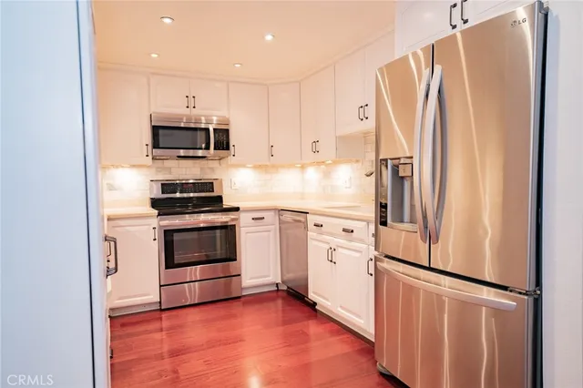 a kitchen with stainless steel appliances a refrigerator stove and microwave