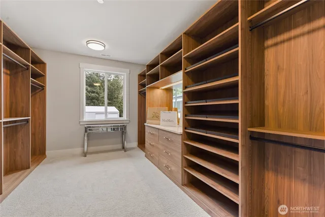 a view of walk in closet and bedroom with wooden floor