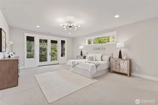 a spacious bedroom with a large bed and a chandelier