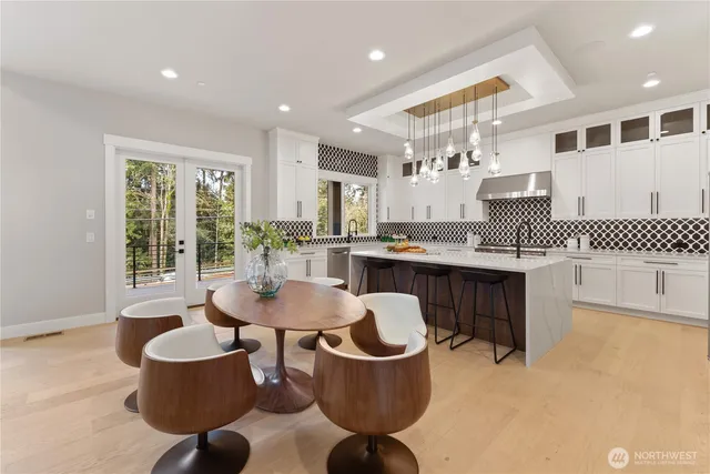 a kitchen with kitchen island granite countertop a white cabinets and chairs