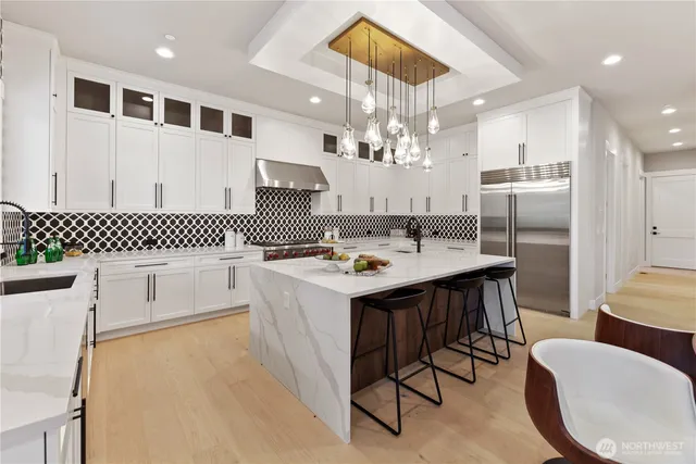 a kitchen with a dining table chairs stainless steel appliances and cabinets