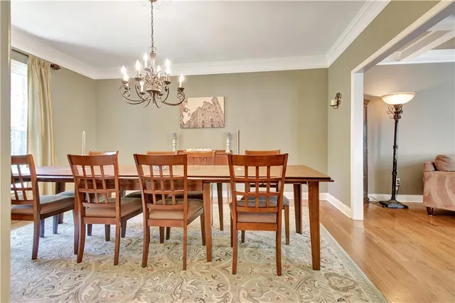 a kitchen with stainless steel appliances granite countertop a table chairs stove and wooden floor