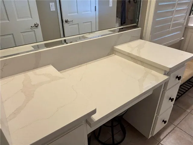 a bathroom with a granite countertop toilet sink and mirror