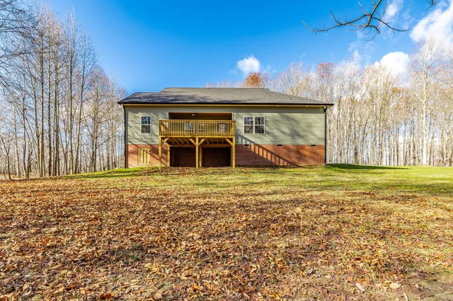 a view of an empty room with a window and a kitchen