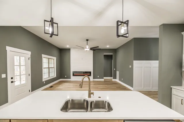 a view of a big room with wooden floor closet and chandelier fan