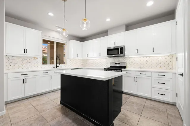 a kitchen with granite countertop cabinets stainless steel appliances and a sink