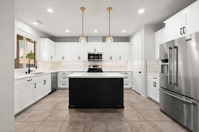 a kitchen with stainless steel appliances granite countertop a sink a refrigerator and a stove