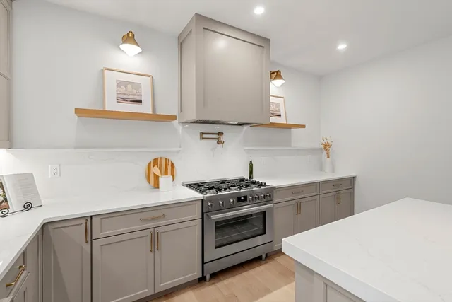 a kitchen with granite countertop a stove a sink and a microwave