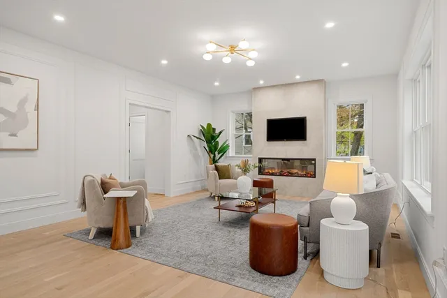 a living room with furniture a flat screen tv and a window