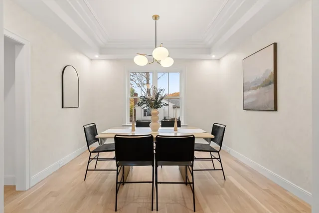 a dining room with wooden floor a chandelier a wooden table and chairs