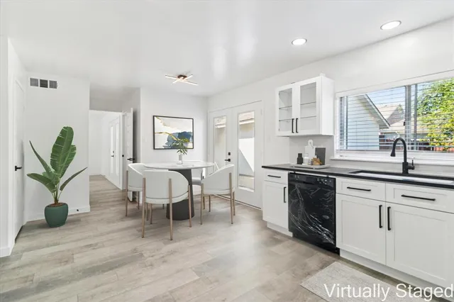 a living room with furniture a potted plant and open kitchen view