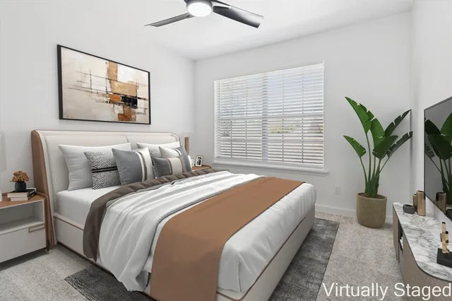 a spacious bedroom with bed and a potted plant