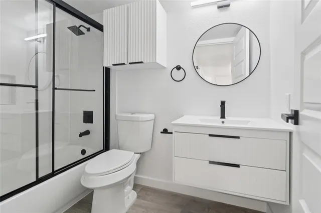 a bathroom with a toilet a sink a mirror and shower