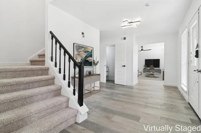 a view of a hallway with wooden floor and staircase