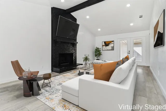 a living room with furniture a fireplace and a flat screen tv