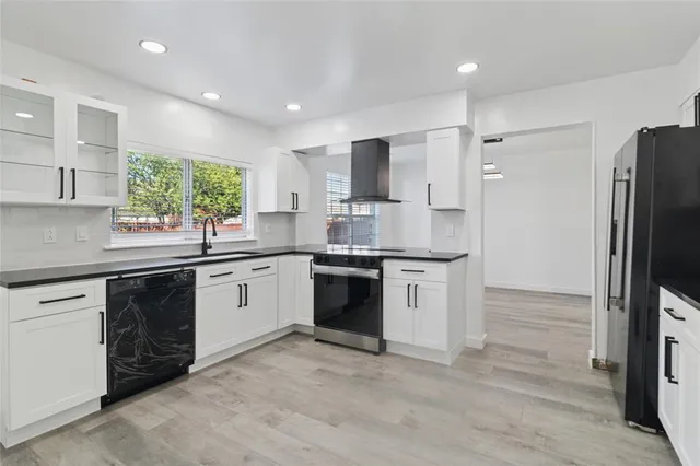 a kitchen with a refrigerator sink and cabinets