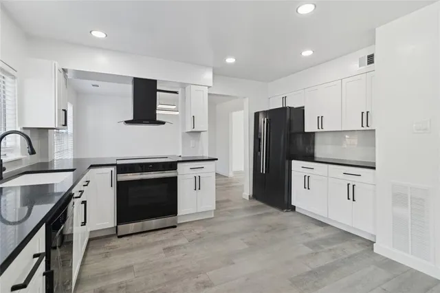 a kitchen with stainless steel appliances granite countertop a refrigerator stove and sink