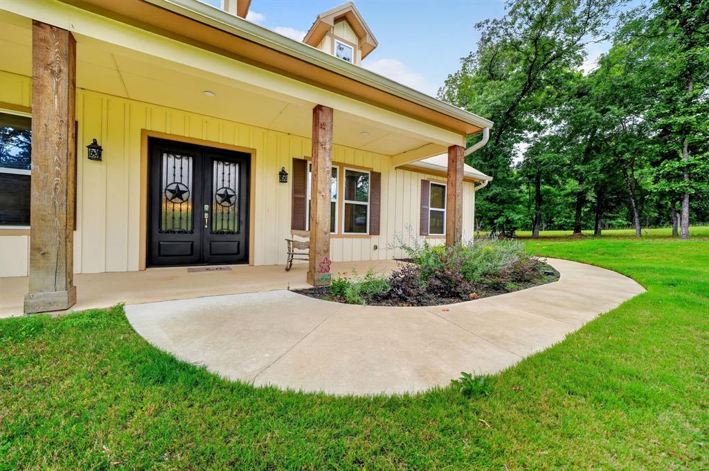 5230 Esquire Estates Road Mabank, TX 75156 - Photo 4 of 39 Covered front porch with substantial wood columns and a concrete pathway