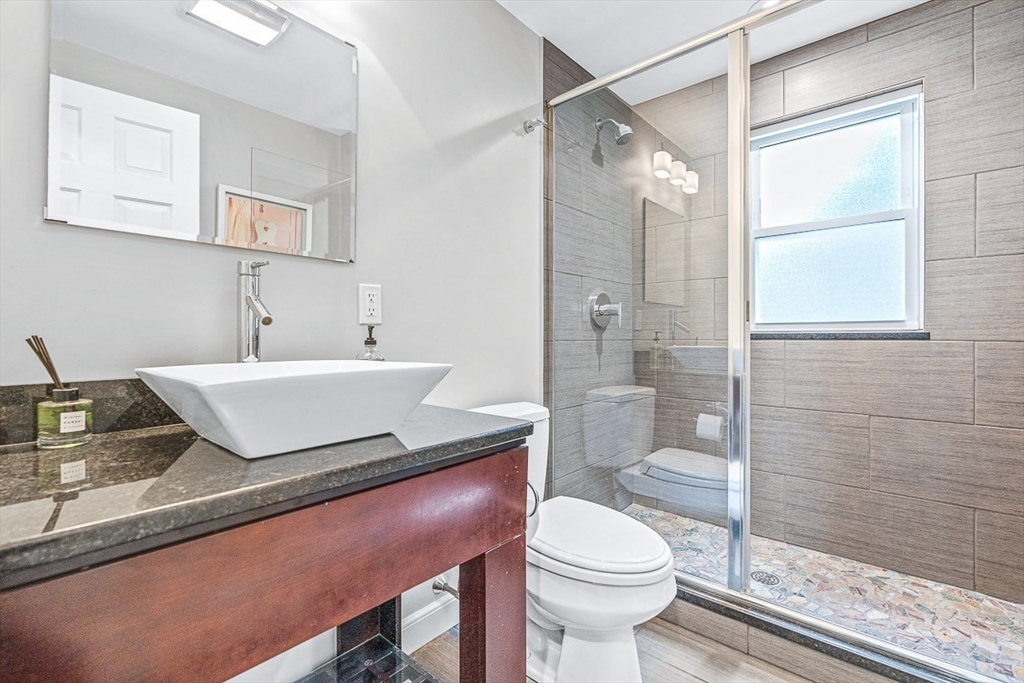 54 Homestead Park Needham, MA 02494 - Photo 20 of 26 a bathroom with a granite countertop sink a toilet a mirror and shower