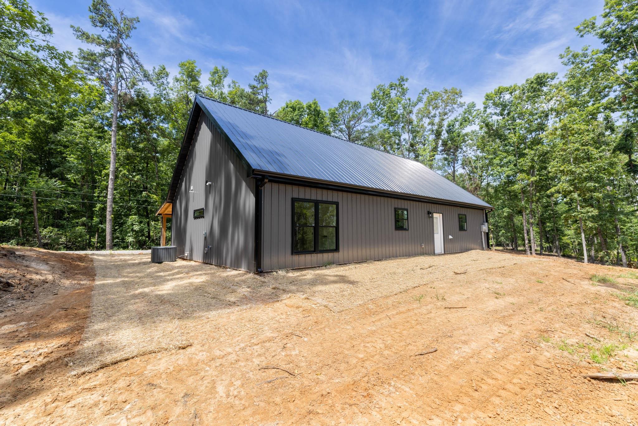 37 William Teague Lane Ramer, TN 38367 - Photo 7 of 39 Modern barn-style structure featuring a metal roof and dark grey siding