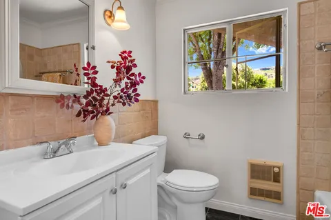 a bathroom with a toilet sink and mirror