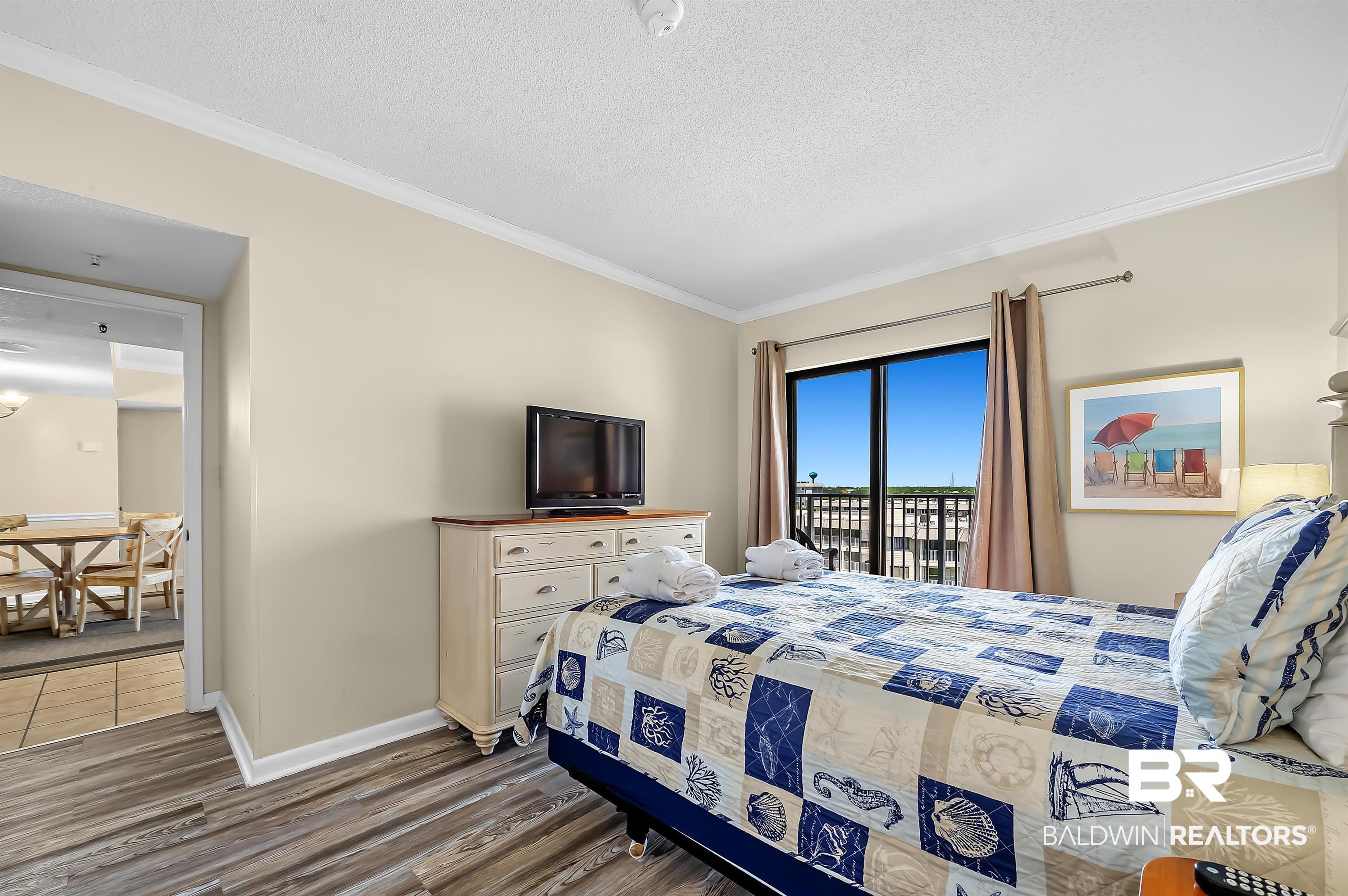 375 Plantation Road, Unit 5409 Gulf Shores, AL 36542 - Photo 16 of 48 Bedroom with access to exterior, crown molding, a textured ceiling, and hardwood / wood-style flooring