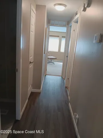 a view of a hallway with wooden floor