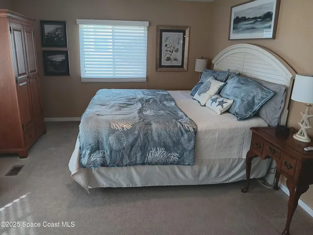 a bedroom with a bed and a painting on the wall