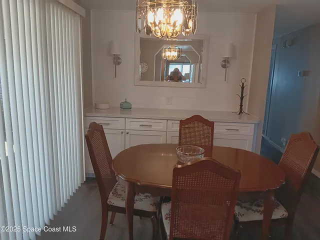 a view of a dining room with furniture and chandelier