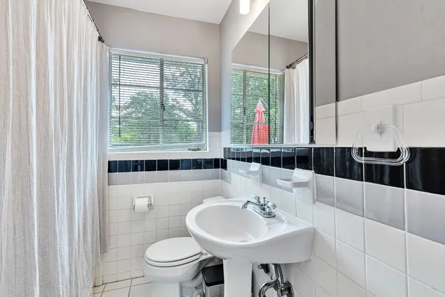 a bathroom with a sink a toilet and mirror
