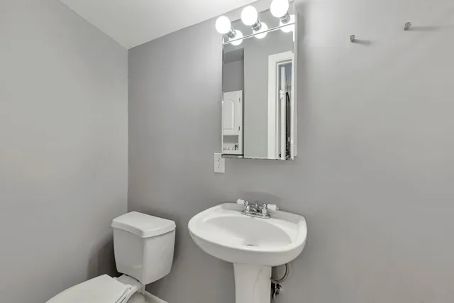 a bathroom with a toilet sink and mirror