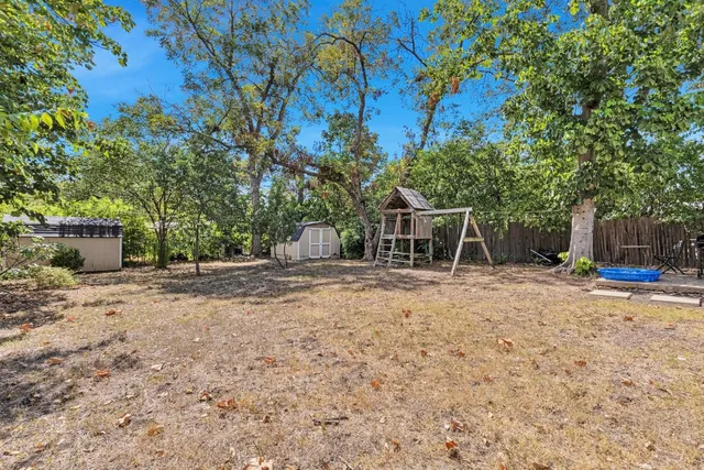 a backyard of a house with table and chairs