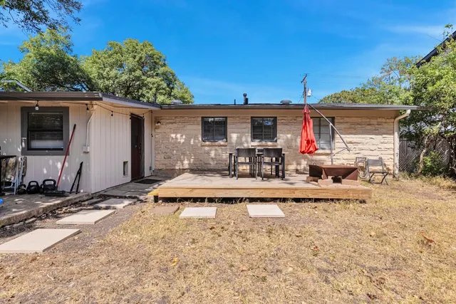 a view of a house with backyard and sitting area