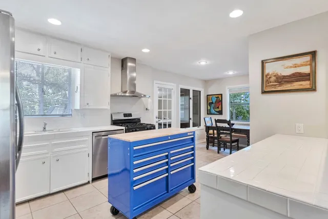 a large white kitchen with sink and cabinets
