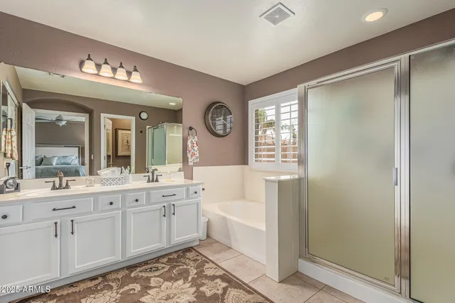 a bathroom with a double vanity sink mirror and bathtub
