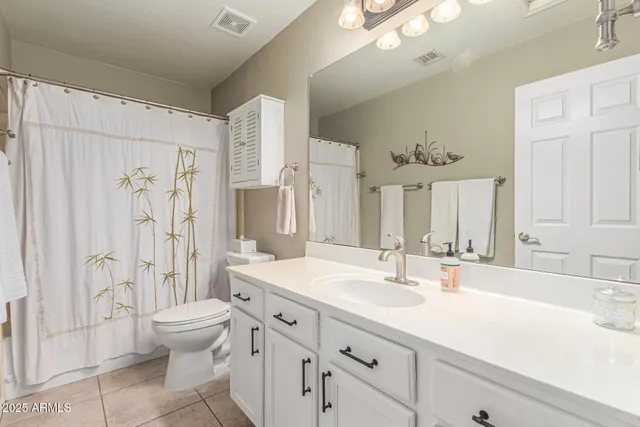 a bathroom with a sink toilet double vanity and shower