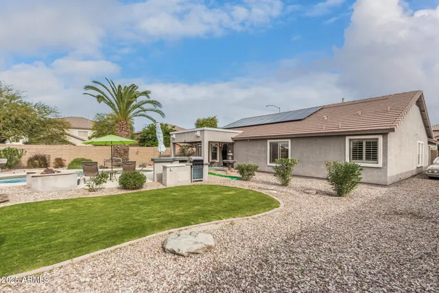 a view of a house with backyard and sitting area