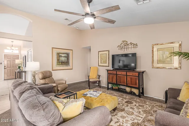 a living room with furniture a flat screen tv and a window