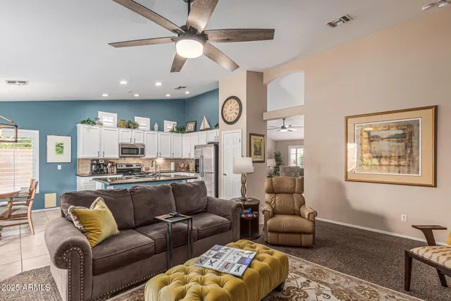 a living room with furniture kitchen view and a chandelier