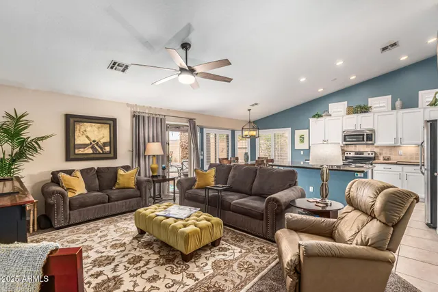 a living room with furniture ceiling fan and a rug