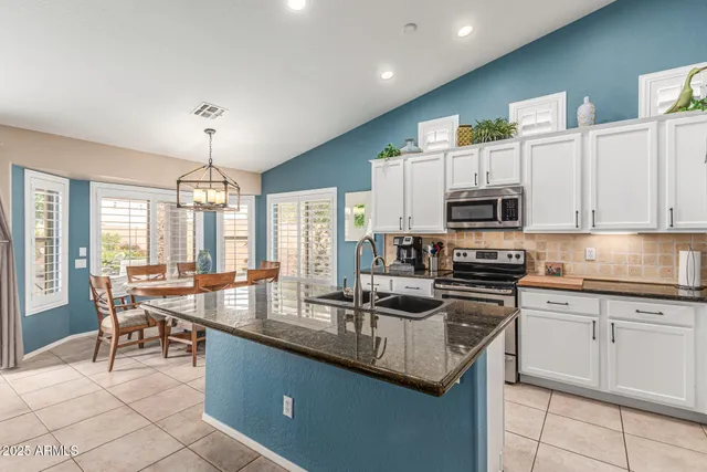 a kitchen with stainless steel appliances granite countertop a stove a sink a microwave and a refrigerator